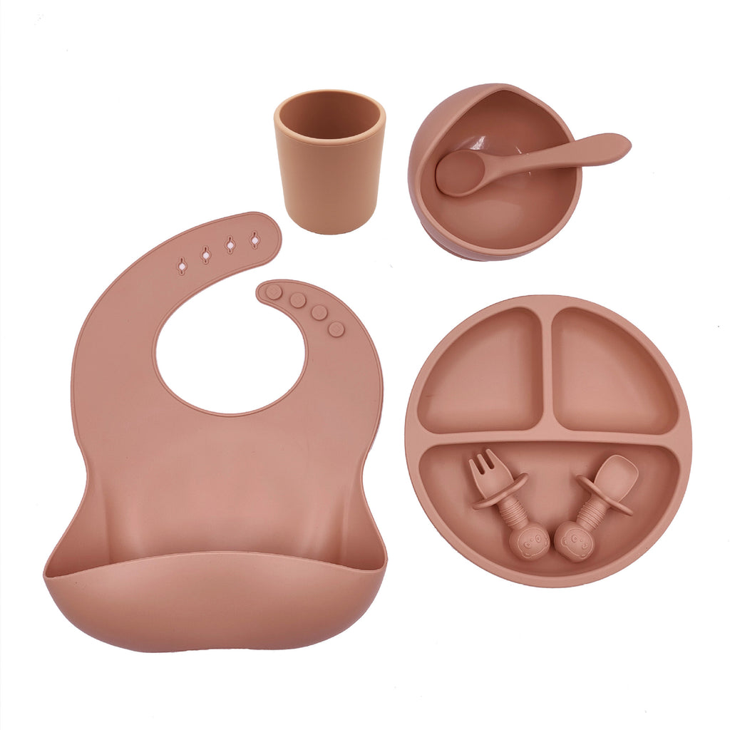 Cozy Cub baby feeding set with orange silicone bib, cup, and spoon, designed for young children and early feeding.