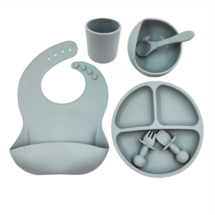 Cozy Cub baby feeding set with orange silicone bib, cup, and spoon, designed for infants and young children.