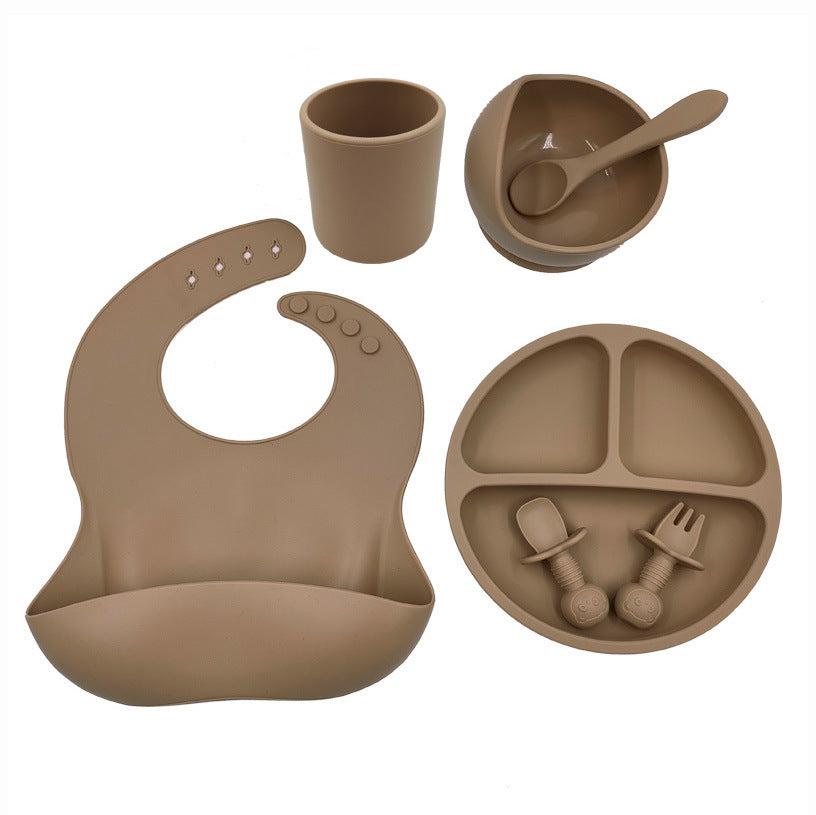 Cozy Cub baby feeding set with silicone bib, cup, and spoon for toddlers, featuring bright orange color and soft, child-friendly materials.