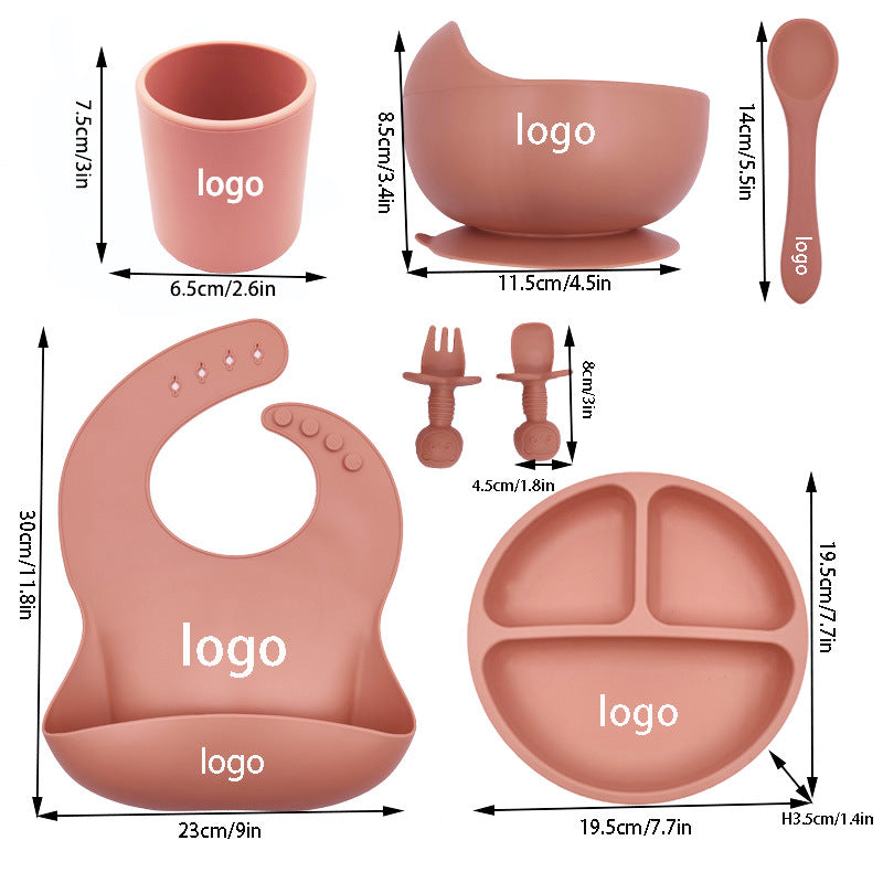 Cozy Cub baby feeding set with silicone bib, cup, and spoon in orange, designed for infants' mealtime convenience.