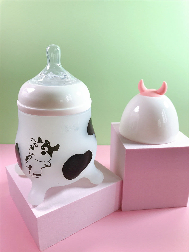 Pink Cozy Cub Wide Neck Baby Bottle with soft silicone feeding nipple, designed for comfortable feeding.