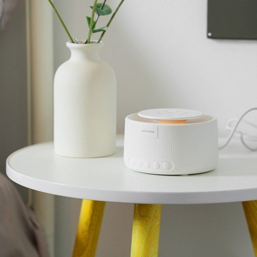 Cozy Cub Smart Baby White Noise Sleep Device emitting soothing sounds, compact white sleep machine for infants' restful sleep.